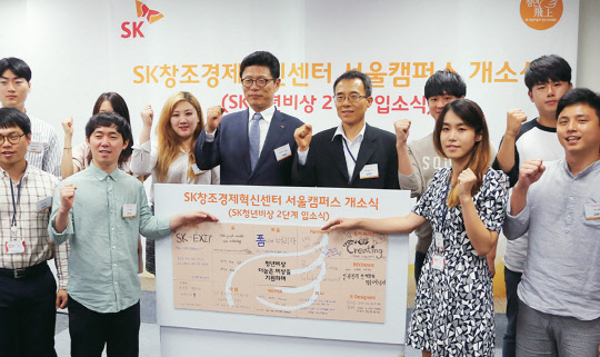 7일 서울 삼일대로에 있는 신한L타워에서 열린 SK창조경제혁신센터 서울캠퍼스 개소식에서 이형희 SK텔레콤 사업총괄(왼쪽에서 여섯번째), 김주한 대통령 비서실 과학기술비서관(왼쪽에서 일곱번째)이 SK청년비상 2단계 입소식에 참가한 대학생들과 파이팅을 외치고 있다.   SK그룹 제공